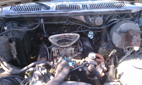 1985 Ford Bronco - The engine bay of a vehicle, showing the carburetor and various engine components.