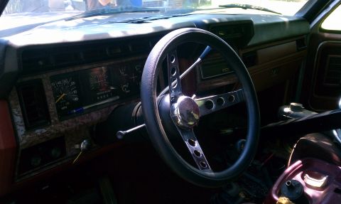 1985 Ford Bronco - The interior of a 1985 Ford Bronco, its dashboard and aftermarket steering wheel.