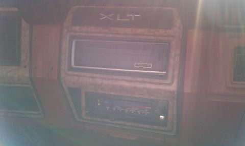 1985 Ford Bronco - Close-up of the dashboard showing the XLT trim and audio system.