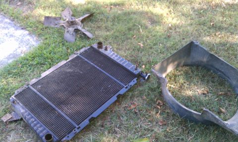 1985 Ford Bronco - Disassembled vehicle cooling components are laid out on the lawn.