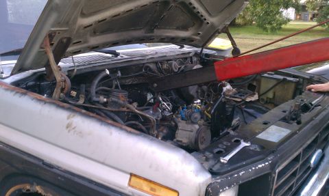 1985 Ford Bronco - Engine bay of a 1985 Ford Bronco, showing the engine and an engine hoist in use.