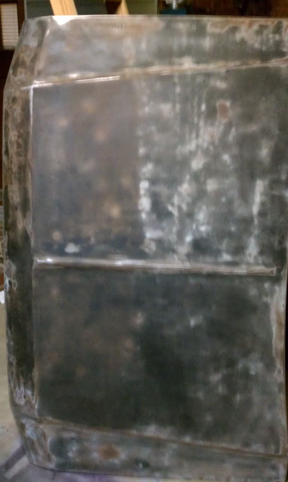 bare metal car hood, looks like it's been worked on