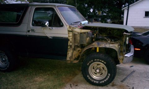 1985 Ford Bronco - This Ford Bronco is undergoing repairs, with its front fender and hood removed to expose the engine bay.