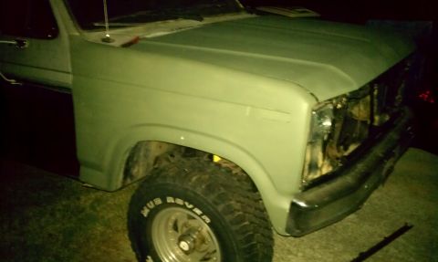 1985 Ford Bronco - This light green Ford Bronco shows damage to its front end and is missing its grille.