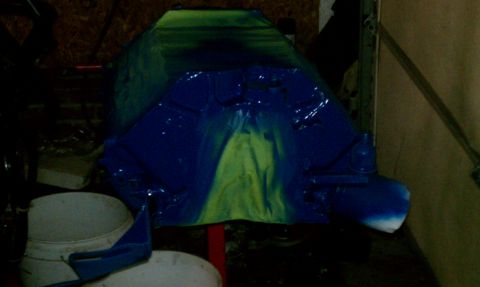 1985 Ford Bronco - Engine block painted with blue and green spray paint, with a white bucket in the foreground.