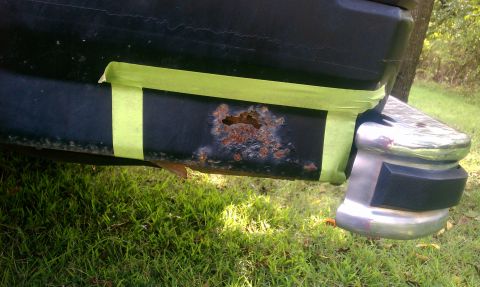 1985 Ford Bronco - Close-up of rusted metal panel on a vehicle, with green tape applied.