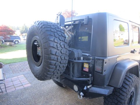 2008 Jeep Wrangler - Black Jeep Wrangler rear view showing spare tire, aftermarket bumper, and taillights.