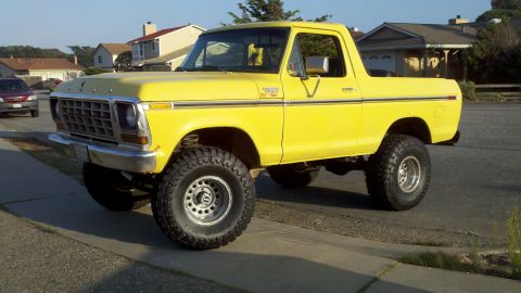 1978 Ford Bronco - A bright yellow 1978 Ford Bronco is shown from a three-quarter front view, lifted with large off-road tires.