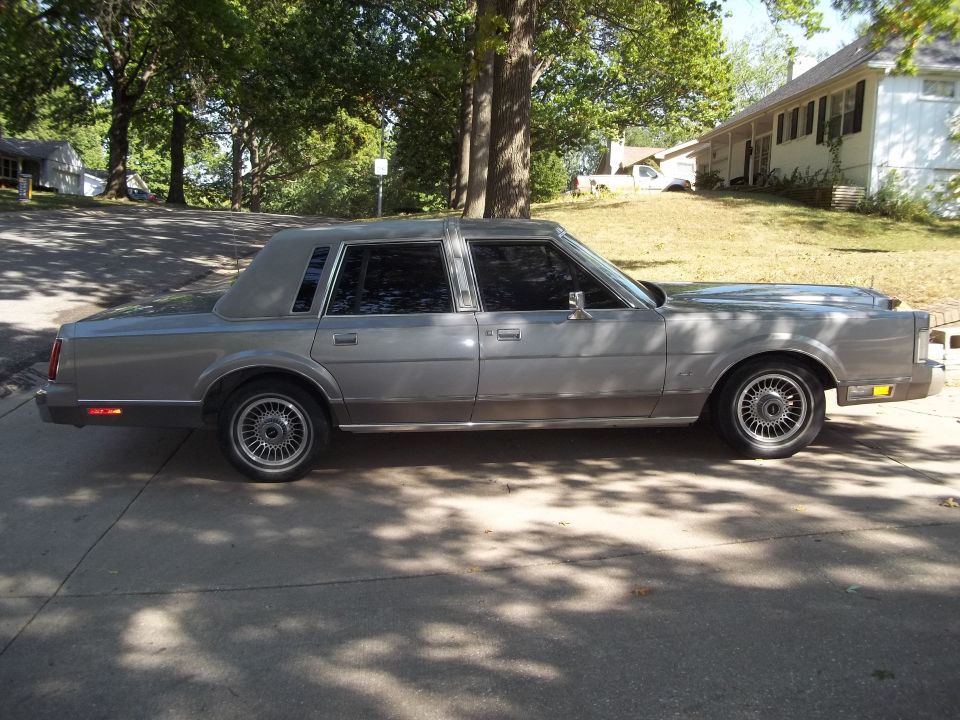 Side view of a gray 1988 Lincoln Town Car parked on a driveway