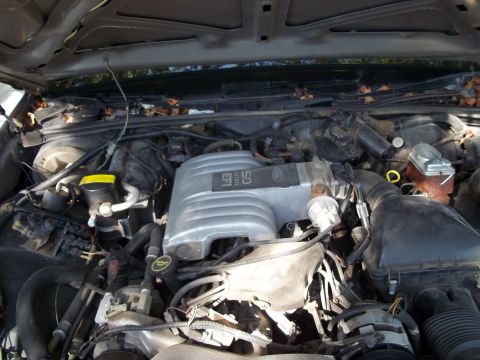 1988 Lincoln Town Car - The engine compartment of a vehicle, showing the V8 engine and various hoses and wires.