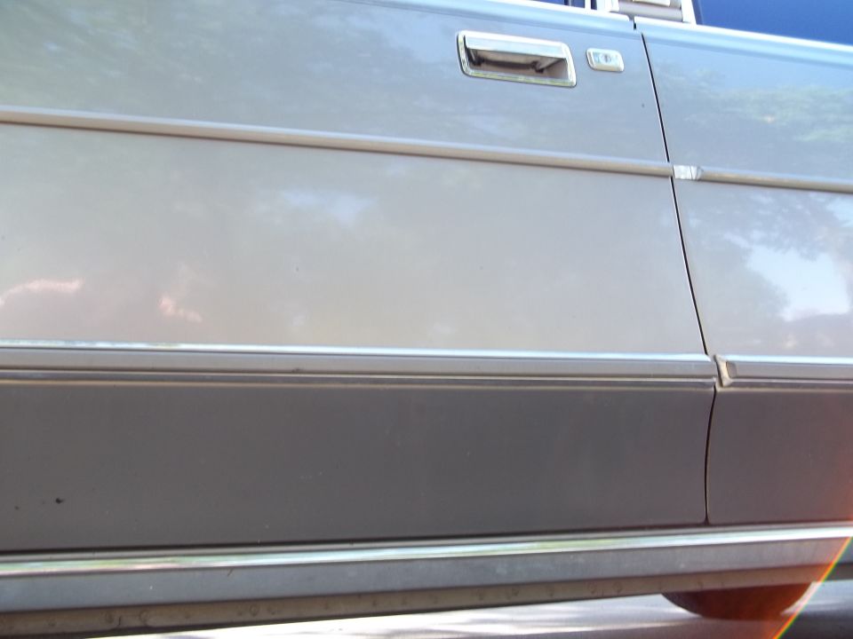 Close-up of two-tone vehicle door with handle and body side molding