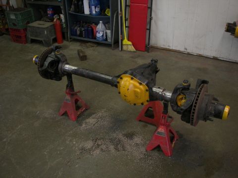 1988 Ford Bronco - Front axle assembly on jack stands, likely for a truck or SUV, in a workshop setting.