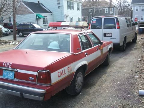 1991 Ford Crown Victoria LTD - Red and white 1991 Ford Crown Victoria LTD police car with emergency lights on the roof.
