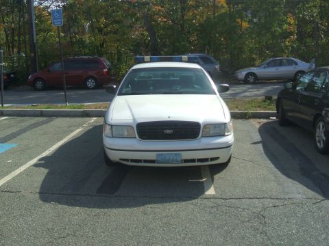 1991 Ford Crown Victoria LTD - A white Ford Crown Victoria police car is parked in a lot with other vehicles visible.