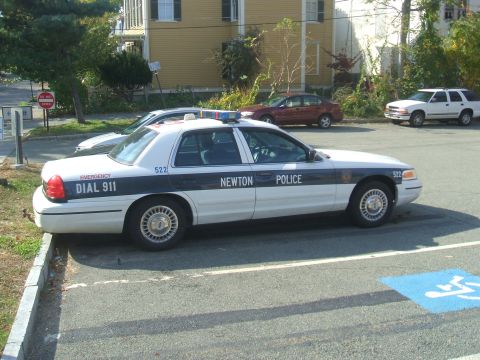 1991 Ford Crown Victoria LTD - Newton Police car, a 1991 Ford Crown Victoria LTD, is parked in a lot next to other vehicles.