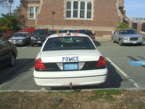 1991 Ford Crown Victoria LTD - White police car with light bar and 'POLICE' markings, parked in a lot with other vehicles.