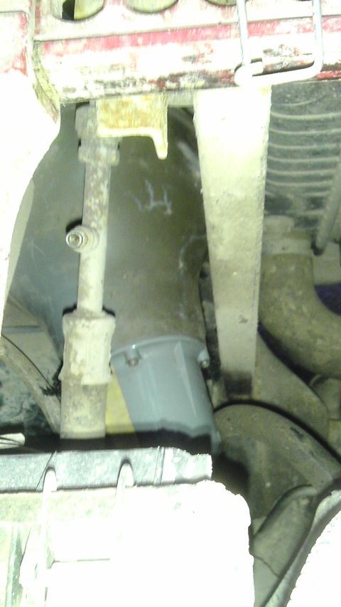 1989 Ford Bronco - A close-up shot reveals the complex undercarriage of a vehicle, suspension parts and various hoses.