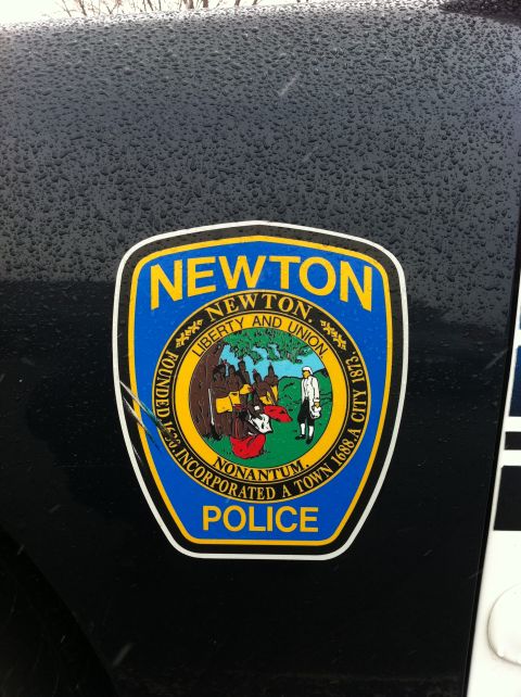 1991 Ford Crown Victoria LTD - A close-up of a Newton Police sticker adhered to the dark exterior of a vehicle.