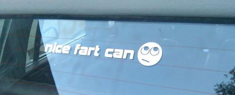 2000 Mercury Grand Marquis - A humorous sticker with a meme face is applied to the rear window of a vehicle.