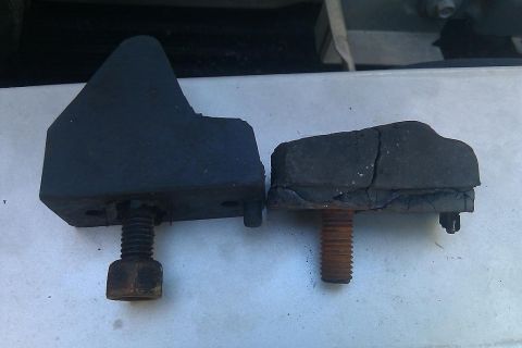 2000 Mercury Grand Marquis - Comparison of a new rubber bumper next to a cracked and worn one, both with mounting bolts.
