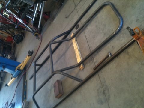 1966 Ford Bronco - A custom-fabricated roll cage frame lies on the shop floor, ready for installation.