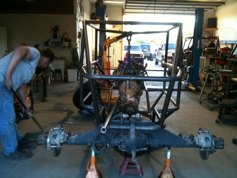 1966 Ford Bronco - Custom off-road chassis being assembled in a workshop with engine and drivetrain components.