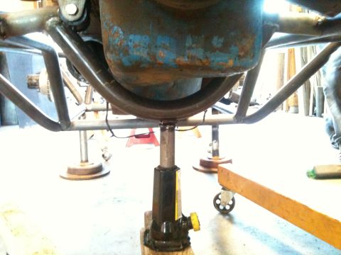 1966 Ford Bronco - The underside of a vehicle is supported by a jack, revealing its mechanical components.