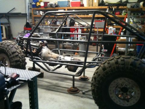 1966 Ford Bronco - Custom off-road buggy frame, engine, and transmission assembly in a workshop setting.