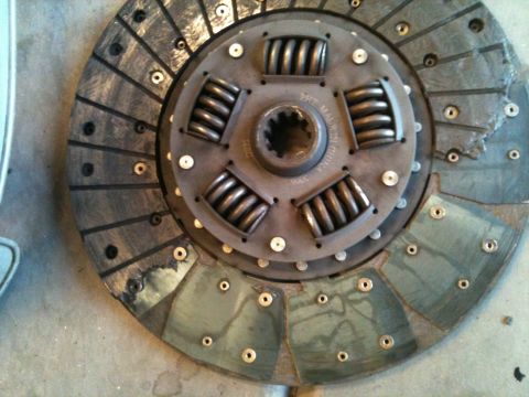 1966 Ford Bronco - A worn clutch disc, likely from a vehicle, displays signs of damage and use.