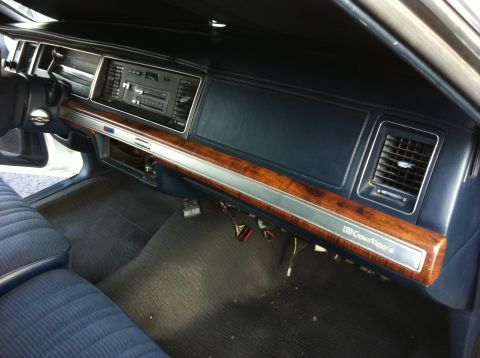 1991 Ford LTD Crown Victoria - Ford LTD Crown Victoria dashboard with blue trim, woodgrain dash strip, radio and vents; LTD Crown Victoria badging visible.