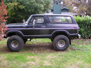 1979 Ford Bronco - Side view of a black Ford Bronco, likely a 1978 model, with custom wheels and off-road tires.