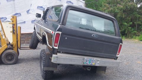 1979 Ford Bronco - A black Ford Bronco with lifted suspension is being moved by a forklift.