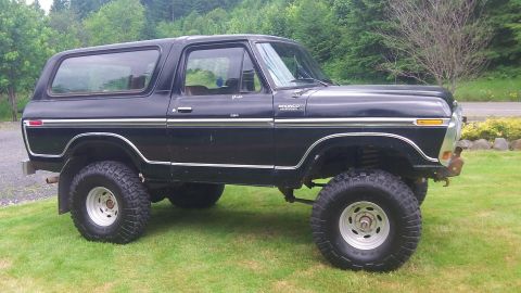 1979 Ford Bronco - Side view of a lifted black 1979 Ford Bronco with off-road tires.