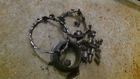 1979 Ford Bronco - Damaged bearing components scattered on a concrete surface, indicating a mechanical failure.