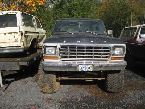 1979 Ford Bronco - A black 1978 Ford Bronco is parked outdoors next to other vehicles.