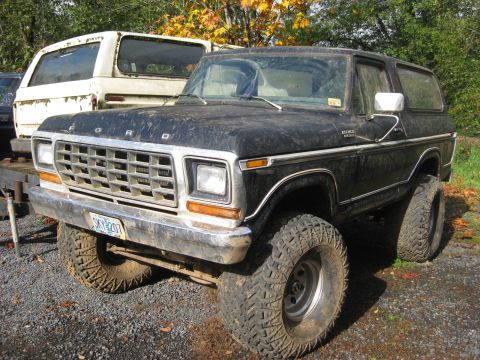 1979 Ford Bronco - This 1979 Ford Bronco features a lifted suspension and aggressive off-road tires, parked next to another SUV.