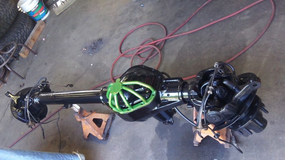 Ford rear axle assembly with green differential cover, on jack stands