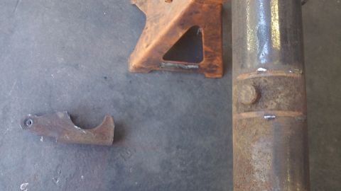 1979 Ford Bronco - Close-up of rusty metal parts and a jack stand on a concrete surface.
