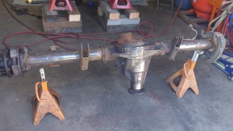 1979 Ford Bronco - A rear axle assembly is supported by jack stands in a garage setting.