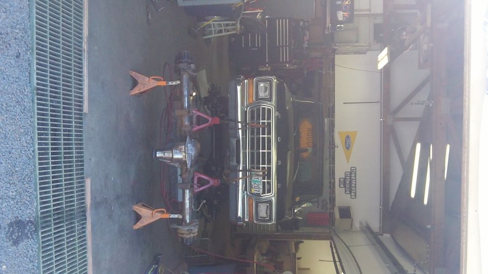 1979 Ford Bronco front end on jack stands, undergoing repairs in a garage