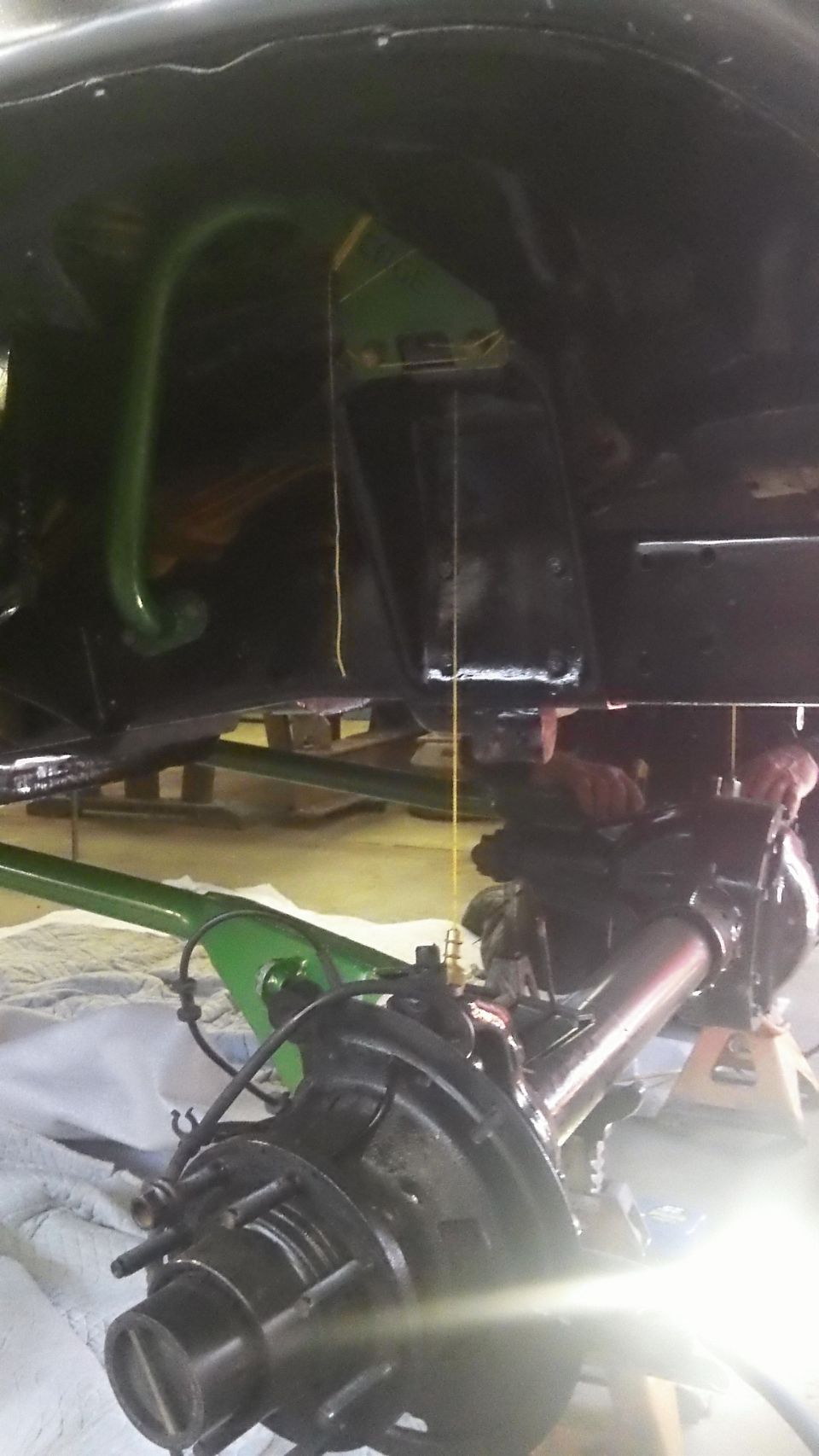 Underside view of a vehicle's rear axle and suspension components, possibly during a repair or modification