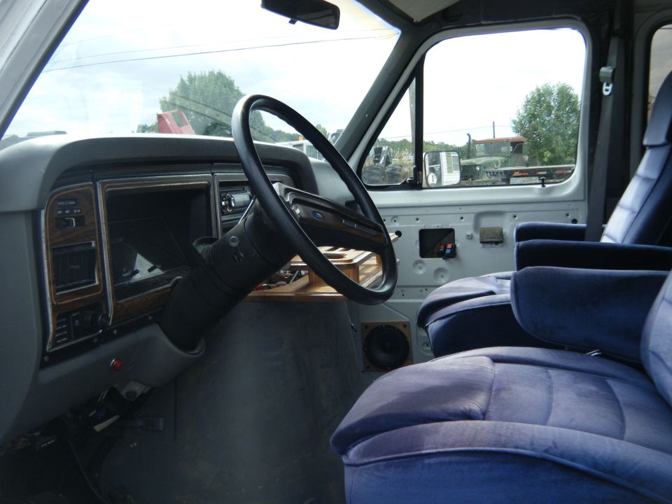 Interior of 1988 Ford E350 van, showing dashboard and blue seats