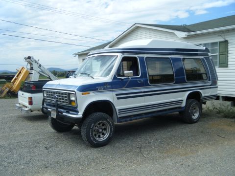 1988 Ford E350 - This 1988 Ford E350 van features a camper top and a two-tone blue and white paint scheme.