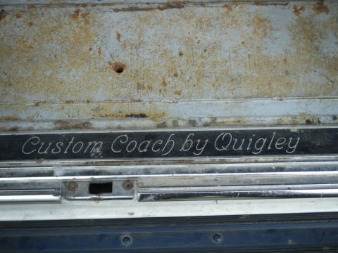 1988 Ford E350 - Detail of a "Custom Coach by Quigley" emblem, indicating aftermarket customization.
