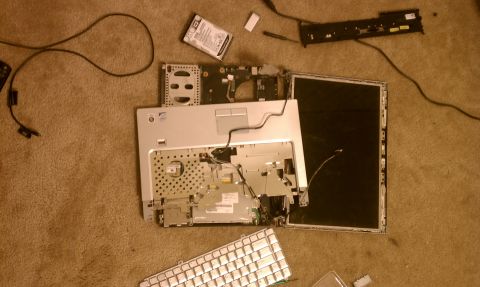 1989 Ford Bronco - Laptop computer disassembled on carpet, showing internal components and keyboard.