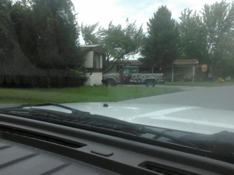1988 Ford Bronco - A pickup truck with a unique camouflage wrap is parked in a residential area.