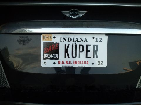 2010 MINI Cooper - Rear view of a MINI Cooper showing an Indiana license plate with custom text and a D.A.R.E. sticker.