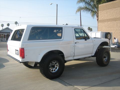 1995 Ford Bronco - This modified SUV features oversized tires and a visible roll cage, suggesting it is not a standard 1995 model.