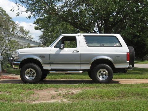 1994 Ford Bronco - This 1994 Ford Bronco is shown from the side, parked on a grassy area next to a driveway.