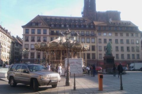 1991 Ford LTD Crown Victoria - A gold Jeep Grand Cherokee is parked in a town square a carousel and historic buildings.